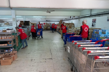 Diversos voluntaris de Creu Roja empaquetant productes.