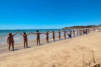 Una vintena d'usuaris van participar en la cadena humana del Club Català de Naturisme a la platja de la Savinosa.