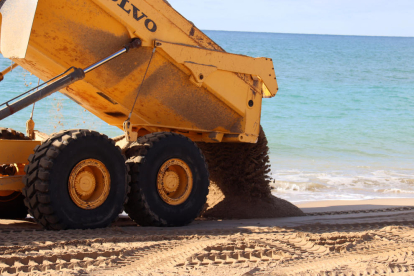 Un camió abocant sorra a la platja d'Altafulla.