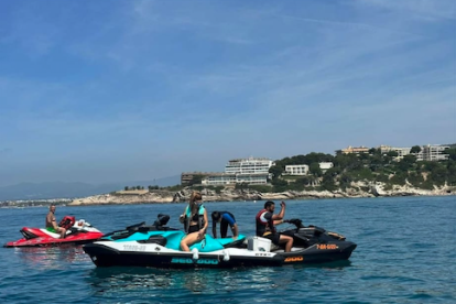 Uns usuaris fent ús de les seves motos aquàtiques particulars a una platja de Tarragona.