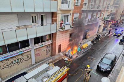 Els Bombers apagant l'incendi d'un contenidor el passat dissabte al carrer Barcelona.