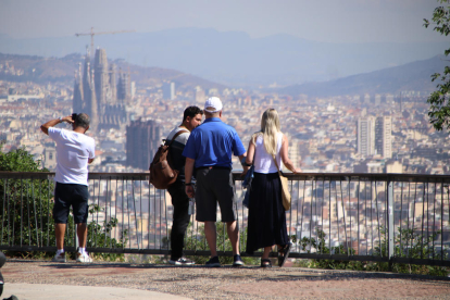 Uns turistes contemplen les vistes de Barcelona des de Montjuïc.