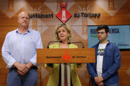 La portaveu de Junts a l'Ajuntament de Tortosa, Meritxell Roigé, compareix a la sala de premsa de l'Ajuntament flanquejada pels regidors Jordi Sorolla i Òscar Ologaray.