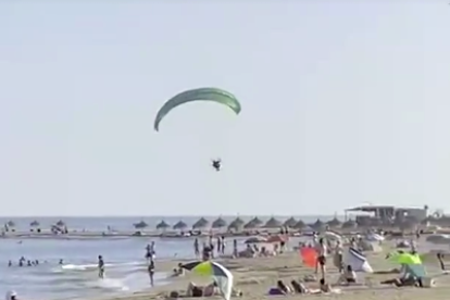 Momento en que el parapente aterriza en la playa en Cambrils.