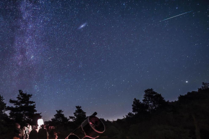 Un dels telescopis del Parc Astronòmic i persones contemplant el cel nocturn.