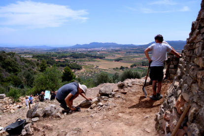 Treballs a la part superior del jaciment del Coll del Moro, amb el poble de Gandesa al fons.