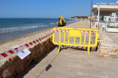 La platja d'Altafulla tancada al públic mentre una màquina arregla els desperfectes.