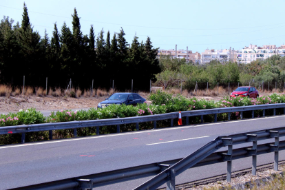 Imatges del tram de l'autopista AP-7 amb marques de la investigació de l'accident per part dels Mossos i el nucli urbà de l'Ametlla de Mar, al fons.