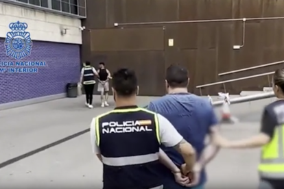 Agents de la Policia Nacional transportant els detinguts en l'operació.