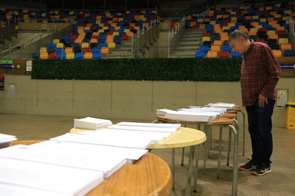 Un hombre mirando las papeletas en la Tarraco Arena por las elecciones del 28-M.