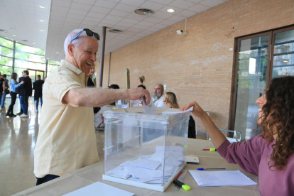 Un home diposita el seu vot en una de les meses constituïdes al Palau Firal de Tarragona.