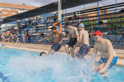 Un grup de joves llançant-se a la piscina del Club Natació Reus Ploms.