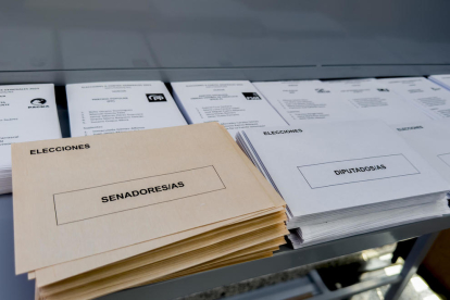 Paperetes, sobres, taules i aigua, disposats en un col·legi electoral.