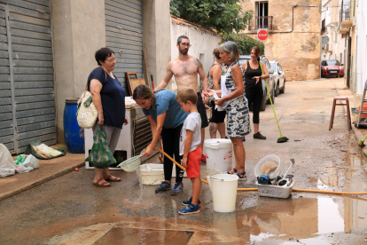 Veïns de Santa Bàrbara l'endemà dels aiguats netejant els baixos inundats pels forts aiguats.