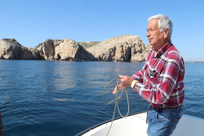 El meteoròelg Josep Pascual recull la corda d'una sonda que utilitza per mesurar la temperatura de l'aigua amb les illes Medes de fons.