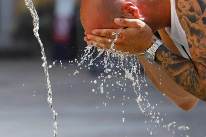 Imatge d'arxiu d'un turista refrescant-se durant una onada de calor.