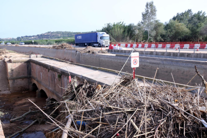 Broza acumulada junto al viaducto del canal de la Derecha del Ebro sobre el barranco de la Galera y tráfico por la C-12, al fondo.