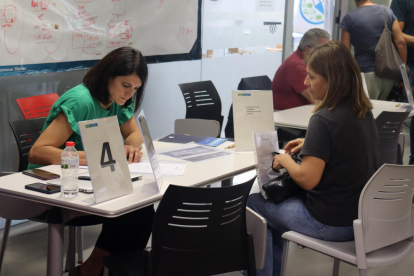 Una dona entregant el seu currículum a una de les empreses participants al Job Dating a Tarragona.