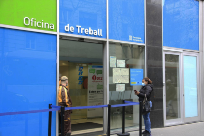 Una dona esperant el seu torn per entrar a l'Oficina de Treball.