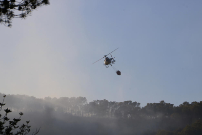 Un helicóptero de los Bomberos de la Generalitat, desde La Pobla de Montornès, durante los trabajos de extinción del incendio forestal de Vespella de Gaià.