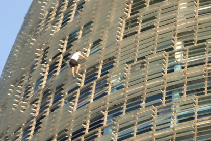 Imatge d'un dels homes escalant sense protecció la Torre Glòries de Barcelona.