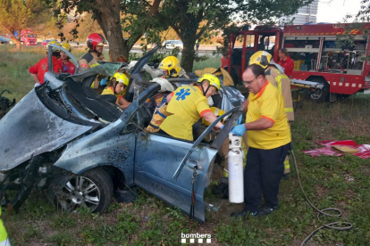 Bombers treballant per treure la víctima del vehicle.