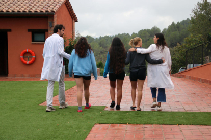 Usuàries i dos psicòlegs de Can Ros passejant per l'exterior del centre.