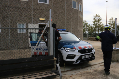 Una patrulla dels Mossos d'Esquadra s'emporta un dels detinguts a la nau del carrer Rovira i Virgili de Reus.