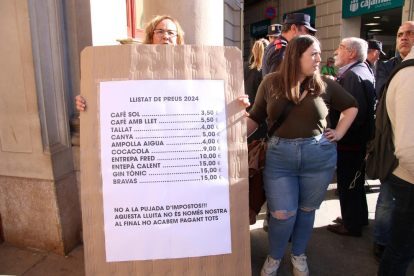 Una dona subjectant un cartell en la protesta feta a la plaça del Mercadal contra la pujada dels impostos a Reus.