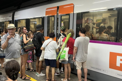 Persones que agafen un tren en direcció a la costa a l'estació Clot-Aragó de Barcelona.
