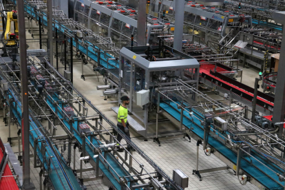 Treballador de Coca-Cola entre la maquinària de la fàbrica de Martorelles.