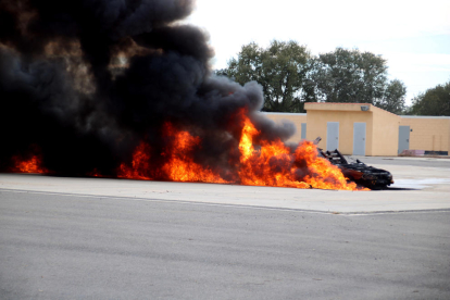 Imagen del vehículo que se ha incendiado, simulando que era un avión, durante el simulacro de accidente aéreo en el aeropuerto de Reus.