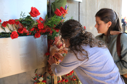 La Marta i Sandra Gascón, mare i filla, col·loquen un clavell al Memorial de les Camposines en honor al seu avi i rebesavi respectivament.