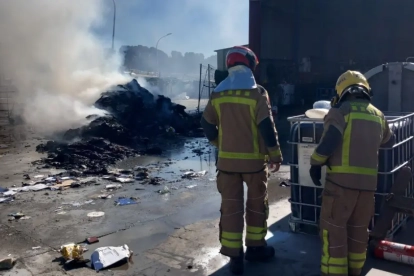 Dos bombers al lloc de l'incendi del camió d'escombraries.