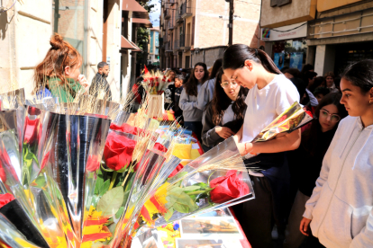Unes noies compren roses al carrer Sant Blai de Tortosa.