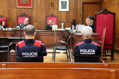 Dos agents dels Mossos d'Esquadra i la cadira de l'acusat d'esquera durant el judici a l'Audiència de Tarragona.