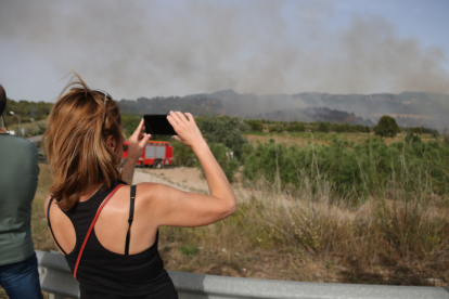 Una dona fotografia l'incendi que ha obligat a evacuar un càmping de Montblanc.