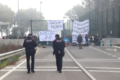 Dos agents dels Mossos d'Equadra davant les portes del centre penitenciari Mas d'Enric durant la jornada de protesta.
