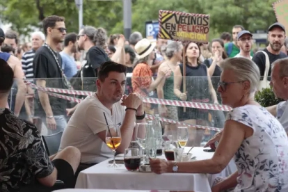 Varios turistas en una terraza de un bar durante la manifestación.