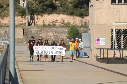 Participants a la Marxa dels Sediments mentre creuen a peu la presa del pantà de Riba-roja.