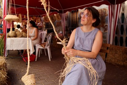 Una artesana treballa un trenat a la seva parada de la Fira de Mas de Barberans