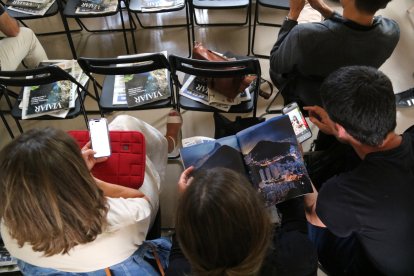 Assistents al Terres Travel Festival fullejant revistes de viatges en paper i digitals en la jornada professional al Museu de Tortosa.