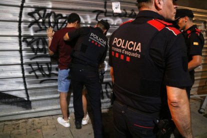 Els agents dels Mossos escorcollen un jove a les festes de Santa Tecla.