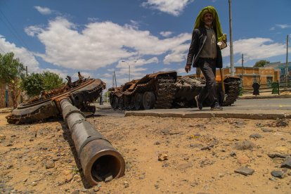 Un home passa per un tanc destruït al carrer principal d'Edaga Hamus, a la regió de Tigray, a Etiòpia.