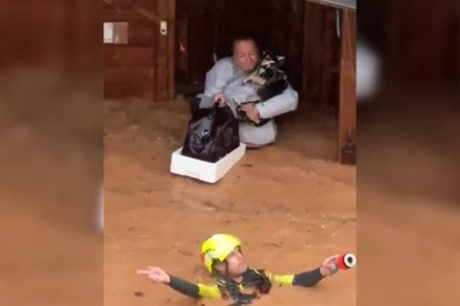 Captura d'un vídeo facilitat per la UME del rescat d'una dona amb les mascotes de casa de fusta a Utiel (València) inundada per la dona