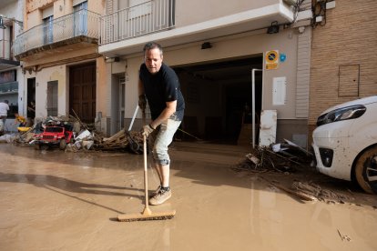 Un veí de l'Alcúdia, netejant el carrer després del pas de la dana.