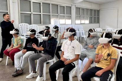 Un grup d'alumnes amb ulleres de realitat virtual fent el taller contra el ciberassetjament i la violència masclista.