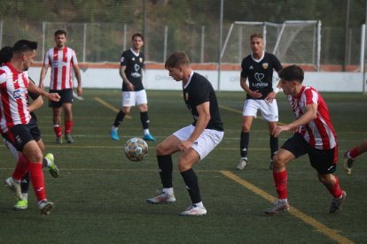 L’atacant pobletà Albert Querol entre dos jugadors de la UE Valls.