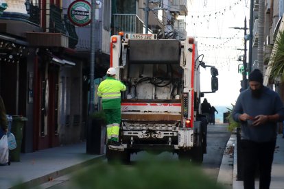 Un camió de la brossa recollint les escombraries del passeig marítim de Calafell