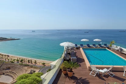 Imatge de la piscina al terrat de l'Hotel H10 Imperial Tarraco, amb vistes a l'amfiteatre romà de Tarragona i el Mar Mediterrani.